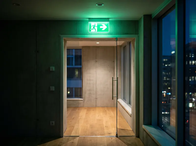 A green emergency exit sign above a door