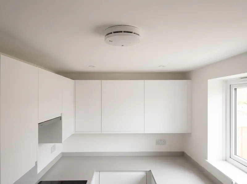 A heat detector on a kitchen ceiling
