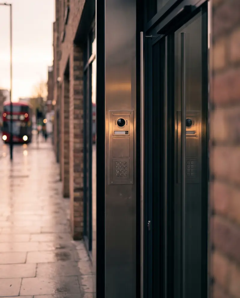 A video intercom panel beside a glass entrance door