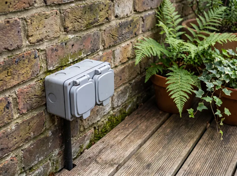 A weatherproof outdoor socket on a garden wall